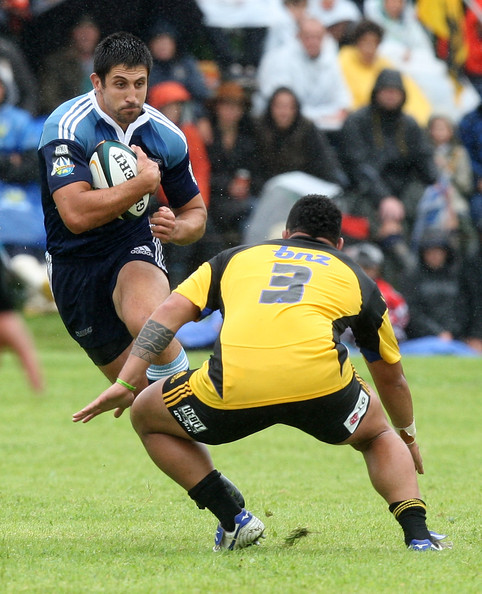 Paul Williams of the Blues gets tackled by Anthony Perenise of the Hurricanes during a Super 14 Trial match between the Hurricanes and the Blues at Mangatainoka Rugby grounds on January 23, 2010 in Mangatainoka, New Zealand. (January 22, 2010 - Photo by Marty Melville/Getty Images AsiaPac) 
